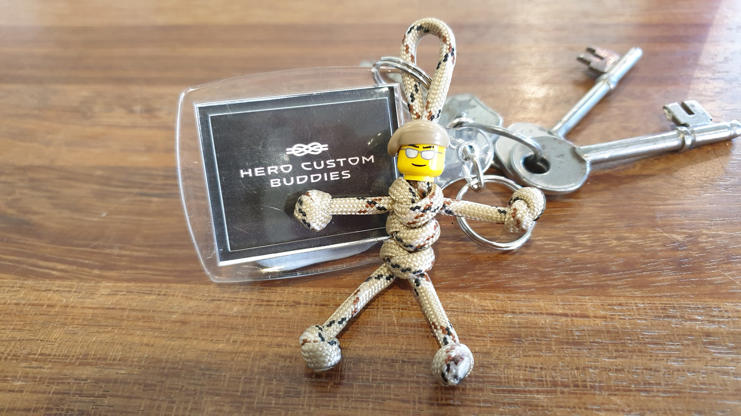 keychain made with desert camouflage coloured paracord and building block head with a beige beret. Paracord is styled with snake knots to look like a little army soldier