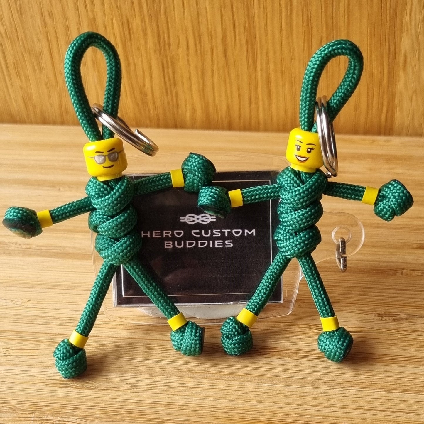 green paracord paramedic shaped keychains with yellow banding on the arms and legs  with male and female building block heads