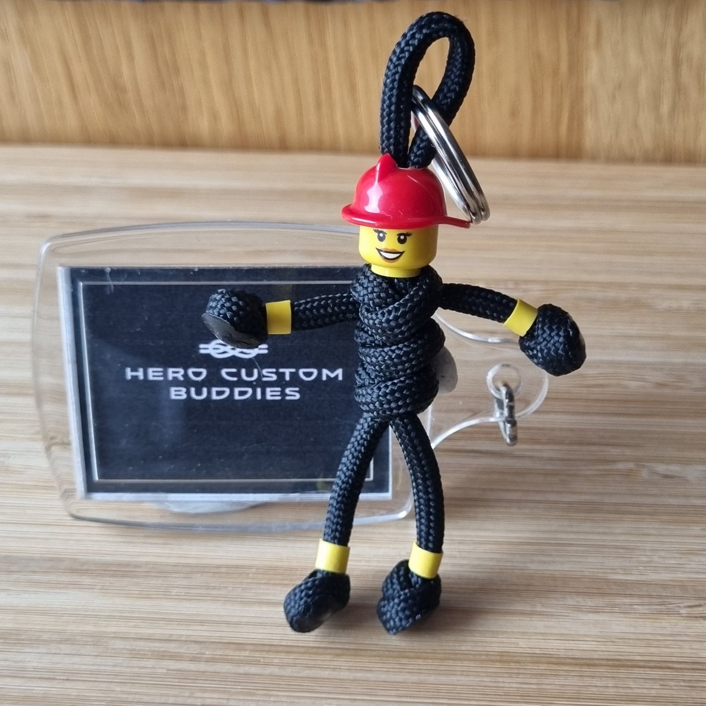 Female firefighter keychains made with black paracord and red building block helmet