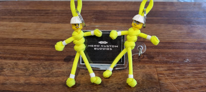 Male and female construction worker keychains made with fluorescent yellow paracord and white building block hard hat and head