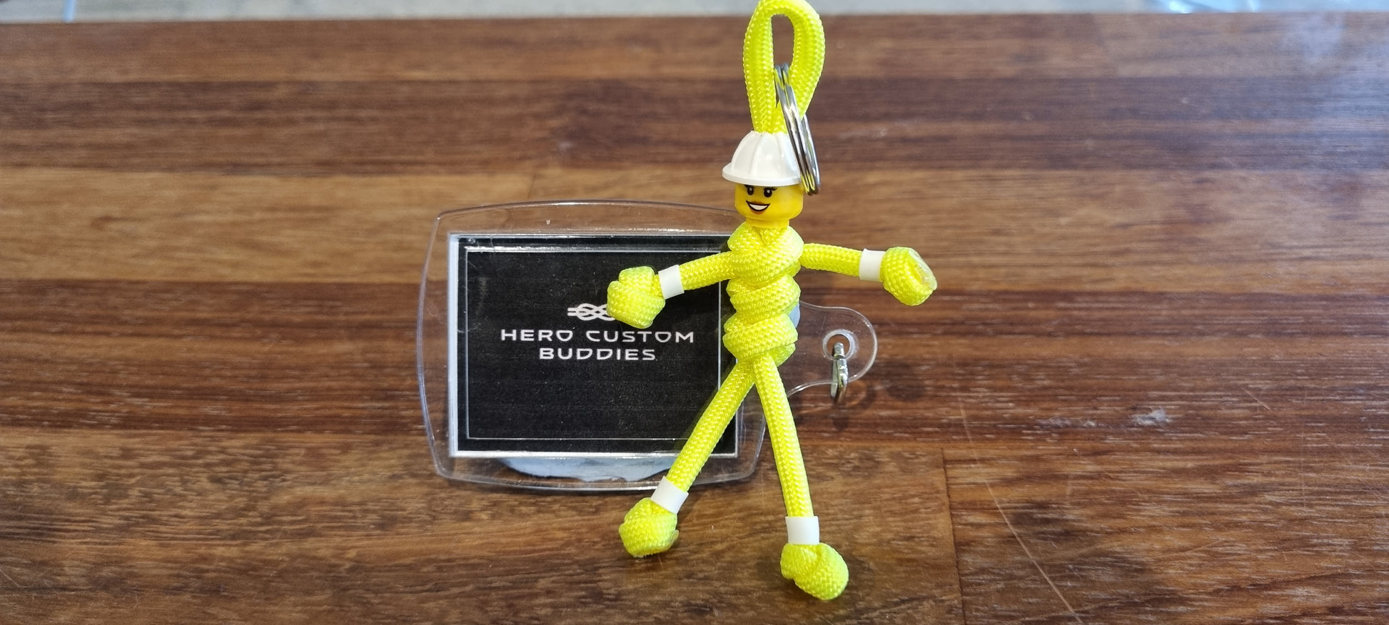 Female construction worker keychains made with fluorescent yellow paracord and white building block hard hat and head