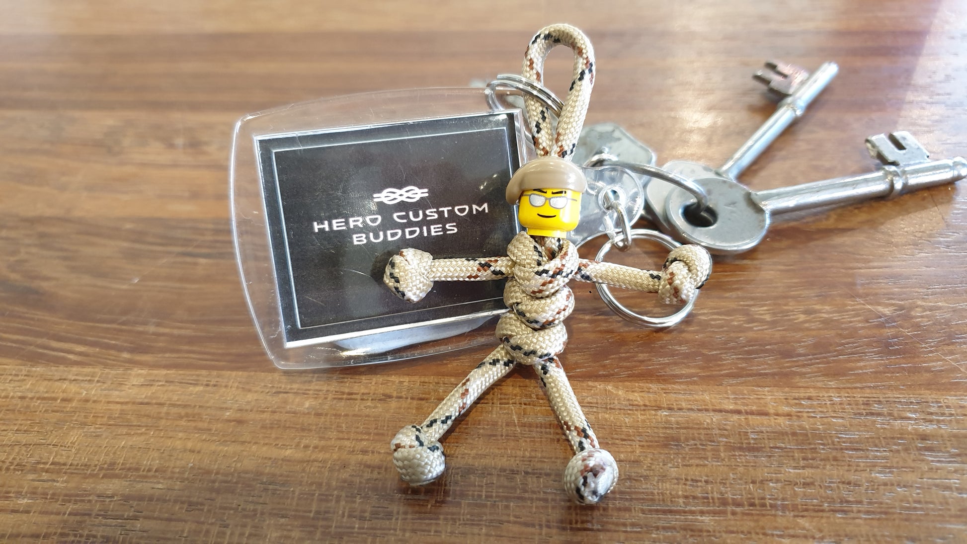 keychain made with desert camouflage coloured paracord and building block head with a beige beret. Paracord is styled with snake knots to look like a little army soldier